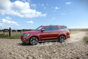 Red 2021 Ford Expedition off-roading on a sandy beach.